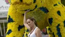Seorang pengunjung sedang berpose bersama macan besar yang terbuat dari rangkaian bunga. Foto diambil pada 31 Juli 2014 saat Festival Bunga Medellin di Kolombia (AFP PHOTO/Raul ARBOLEDA)