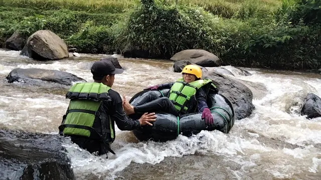 Salah satu pengunjung tengah menikmati sajian river tubing di kawasan wisata air Sindangkasih, Cilawu Garut, Jawa Barat. (Liputan6.com/Jayadi Supriadin)