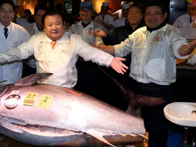 CEO Sushi Zanmai, Kiyoshi Kimura berpose dengan ikan tuna seberat 212 kg di depan restorannya, dekat pasar ikan Tsukiji, Tokyo, Kamis (5/1). Dalam pelelangan pertama tahun 2017, ikan tuna itu terjual 74,2 juta yen (212 kilogram). (TOSHIFUMI KITAMURA/AFP)
