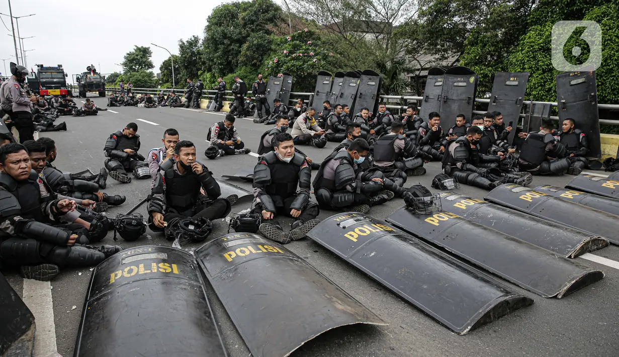 Polisi memblokade massa pendukung Rizieq Shihab di flyover Penggilingan, Jakarta, Kamis (24/6/2021). Sebelumnya, aparat kepolisian dengan para simpatisan Rizieq Shihab terlibat bentrokan jelang sidang vonis perkara tes swab yang digelar di di PN Jakarta Timur. (Liputan6.com/Faizal Fanani)