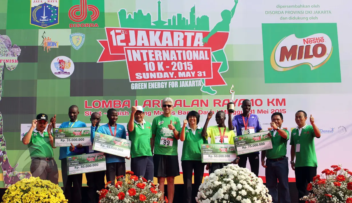 Wagub DKI Djarot Saiful (kelima kiri) dan juara Jakarta International 10K 2015 kategori elit internasional putra, Silas Kiputro (ketiga kanan) berfoto bersama seusai penyerahan hadiah di Silang Monas,  Jakarta, Minggu (31/5). (Liputan6.com/Helmi Afandi)