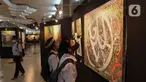 Pengunjung melihat karya pada Pameran Kaligrafi Kontemporer Internasional di Masjid Raya Jakarta Islamic Center, Jakarta, Senin (18/4/2022). Pameran digelar dalam rangkaian peringatan Nuzulul Quran itu menghadirkan lebih dari 100 karya seniman kaligrafi dari 26 negara. (Liputan6.com/Herman Zakharia)