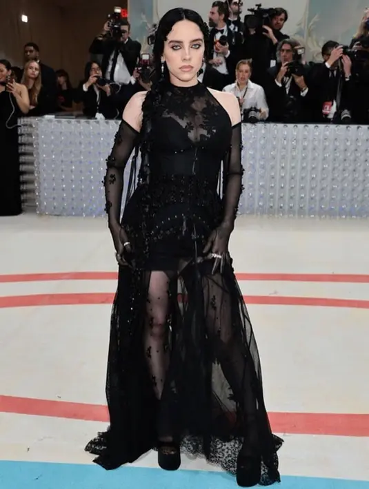 Gaun transparan Simone Rocha yang dikenakan Billie Eilish memiliki potongan halterneck dan penuh payet. Billie Eilish terlihat seksi dengan sarung tangan transparan [@aplasticplant]