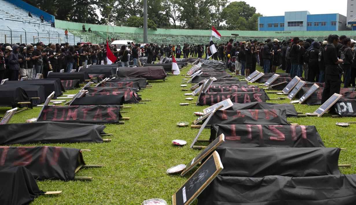 Pengunjuk rasa membawa keranda jenazah yang mewakili korban Tragedi Kanjuruhan pada 1 Oktober, di Malang, Jawa Timur, Kamis (10/11/2022). Unjuk rasa yang diikuti ribuan Aremania tersebut menuntut pemerintah dan aparat penegak hukum menangkap serta mengadili seluruh pelaku yang terlibat dalam kasus tersebut. (AP Photo/Rizki Dwi Putra)