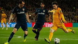 Penyerang Barcelona, Lionel Messi (kanan) berusaha melewati dua pemain bek Atletico Madrid pada leg pertama perempat final Liga Champions di Camp Nou, Spanyol (6/4). Barcelona menang atas Atletico Madrid dengan skor 2-1. (Reuters/Albert Gea)