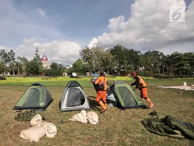 Petugas Penanganan Prasarana dan Sarana Umum (PPSU) mendirikan tenda saat persiapan untuk doa bersama pada malam Tahun Baru di Cipinang Melayu, Jakarta, Minggu (30/12). (Merdeka.com/ Iqbal S. Nugroho)