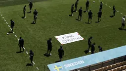 Tim Swedia berpose di sebelah tanda bertuliskan "Get Well Christian" untuk gelandang Denmark Christian Eriksen selama sesi latihan di stadion La Cartuja di Seville, Spanyol, Minggu (13/6/2021). Eriksen pingsan di lapangan saat melawan Finlandia pada grup B Euro 2020. (Julio Munoz/Pool via AP)