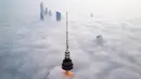Foto udara memperlihatkan pemandangan Liberation Tower (depan) di tengah kabut tebal, Kuwait City, 21 Januari 2023. Liberation Tower adalah menara telekomunikasi setinggi 372 meter atau 1.220 kaki yang menjadi bangunan tertinggi kedua di Kuwait dan bangunan tertinggi ke-39 di dunia. (YASSER AL-ZAYYAT/AFP)