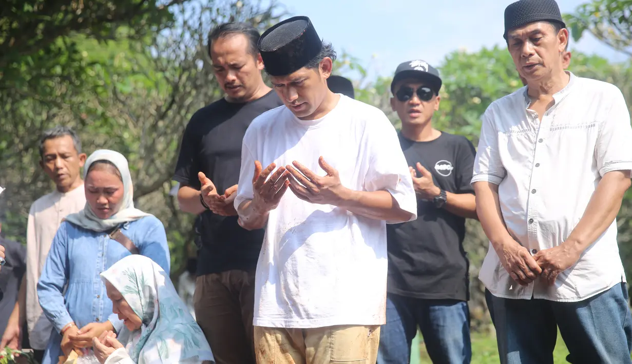Setelah jenazah tertutup tanah, prosesi pembacaan doa dipimpin seorang ustaz. Pria berusia 42 tahun itu tampak khusyu berdoa untuk sang ayah. [Foto: Adrian Putra/Fimela.com]