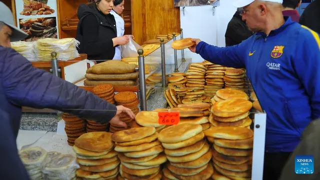 Warga Tunisia juga war takjil atau makanan untuk iftar atau saat berbuka puasa Ramadan, salah satunya roti khas Tunis. Mereka membelinya di sebuah pasar di Tunis, Tunisia. (Foto oleh Adel Ezzine/Xinhua)