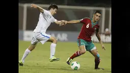 Pemain Timnas Maroko U-17, Sofyan Amrabat (kanan), mengontrol bola dibayangi pemain Uzbekistan U-17, amshid Boltaboev, dalam pertandingan Piala Dunia U-17 2013 yang berlangsung di Uni Emirat Arab, Senin (21/10/2013). Sofyan Amrabat diberikan kesempatan bermain tiga kali bersama Timnas Maroko U-17 di Piala Dunia U-17 2013. (AFP/Karim Sahib)