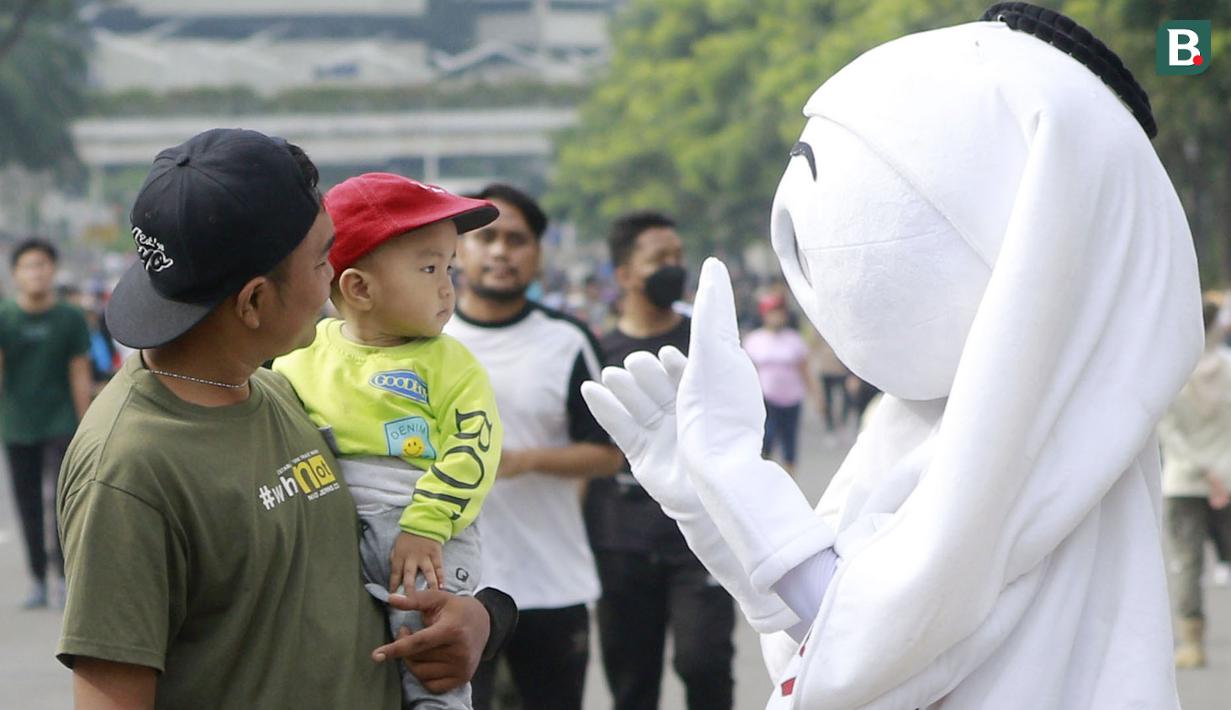 Maskot Piala Dunia 2022, La'eeb, dengan ramah menyapa anak-anak saat Car Free Day (CFD) di kawasan Sudirman, Jakarta, Minggu (06/11/2022). (Bola.com/M iqbal Ichsan)