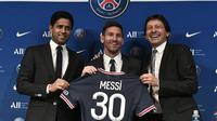 Presiden Paris Saint-Germain (PSG) Nasser Al-Khelaifi (kiri) dan Direktur Olahraga PSG Leonardo Nascimento de Araujo (kanan) berpose Lionel Messi selama pers konferensi di stadion Parc des Princes di Paris, Rabu (11/8/2021). (STEPHANE DE SAKUTIN/AFP)