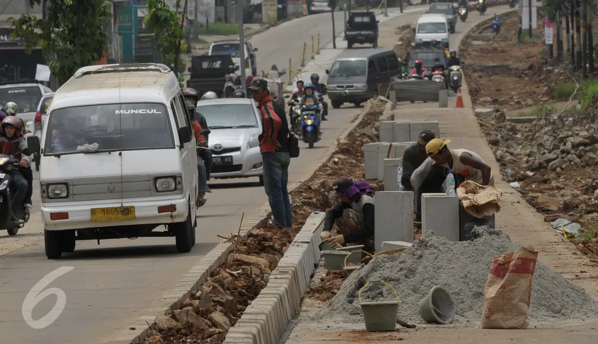 Pekerja saat menyelesaikan proyek rehabilitasi ruas jalan Ciputat-Pamulang, Tangerang Selatan, (28/1). Akibat pengerjaan lalu lintas mengalami kemacetan. (Liputan6.com/Faisal R Syam)