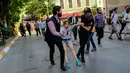 Petugas polisi anti huru hara berusaha menghalangi peserta pawai masuk ke lokasi parade Gay Pride di Istiklal Street Turki, pusat kota Istanbul, bertepatan dengan hari raya Idul Fitri 1438 Hijriah, Minggu (25/6). (YASIN AKGUL/AFP)