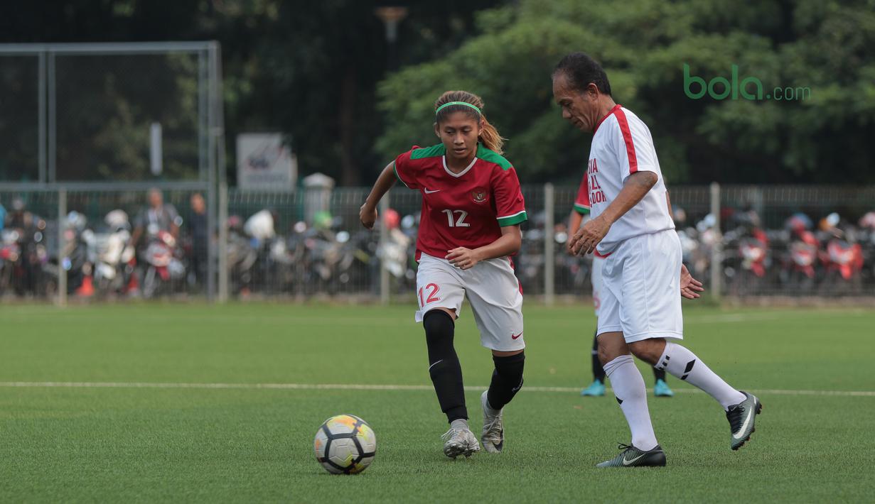 Pemain Timnas Wanita Indonesia, Zahra Musdalifah (kiri) berusaha menutup gerakan pemain Legenda Indonesia pada laga uji coba di Lapangan ABC Senayan, Jakarta, Kamis (5/4/2018). Timnas Wanita Indonesia menang 3-2. (Bola.com/Nick Hanoatubun)