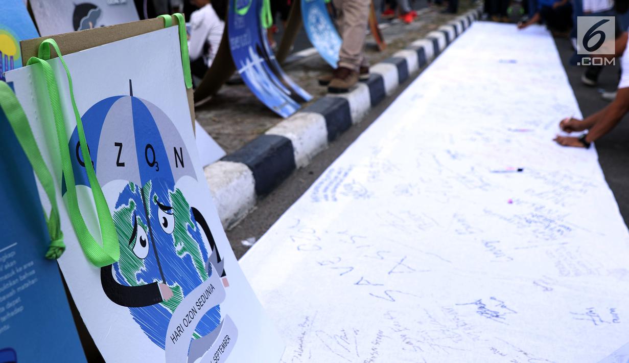 Warga menandatangani kain saat peringatan Hari Ozon Sedunia 2018 di sekitar kawasan Bundaran HI, Jakarta, Minggu (16/9). Acara ini bagian dari peringatan Hari Ozon Sedunia yang jatuhnya setiap tanggal 16 September. (Liputan6.com/Helmi Fithriansyah)