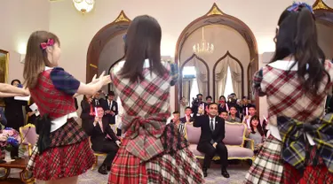 Perdana Menteri Thailand, Prayut Chan-O-Cha menyaksikan grup musik Jepang, AKB48, tampil di Gedung Pemerintahan, Kamis (13/8). Kunjungan ini adalah promosi AKB48 untuk mempersiapkan konser di Bangkok pada Desember mendatang. (HO/ROYAL THAI GOVERNMENT/AFP)