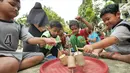 Anak-anak bermain permainan tradisional gasing di RPTRA Melati Duri Pulo, Jakarta, Sabtu (13/10). Traditional Games Returns (TGR) mengampanyekan permainan tradisional dengan mengusung tema "Millenials". (Liputan6.com/Herman Zakharia)