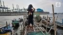 Nelayan membawa wadah berisi ikan di kawasan pesisir Kalibaru, Cilincing, Jakarta Utara, Senin (19/9/2022). Kenaikan BBM bersubsidi jenis solar meyebabkan biaya operasional untuk melaut membengkak, sementara hasil tangkapan dan harga jual ikan saat ini tengah merosot. (merdeka.com/Iqbal S. Nugroho)