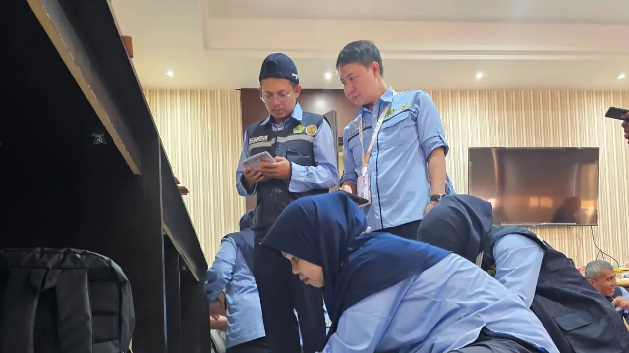 Petugas Haji 2025 membantu proses penyortiran kartu nusuk jemaah haji di ruang Media Center Haji.