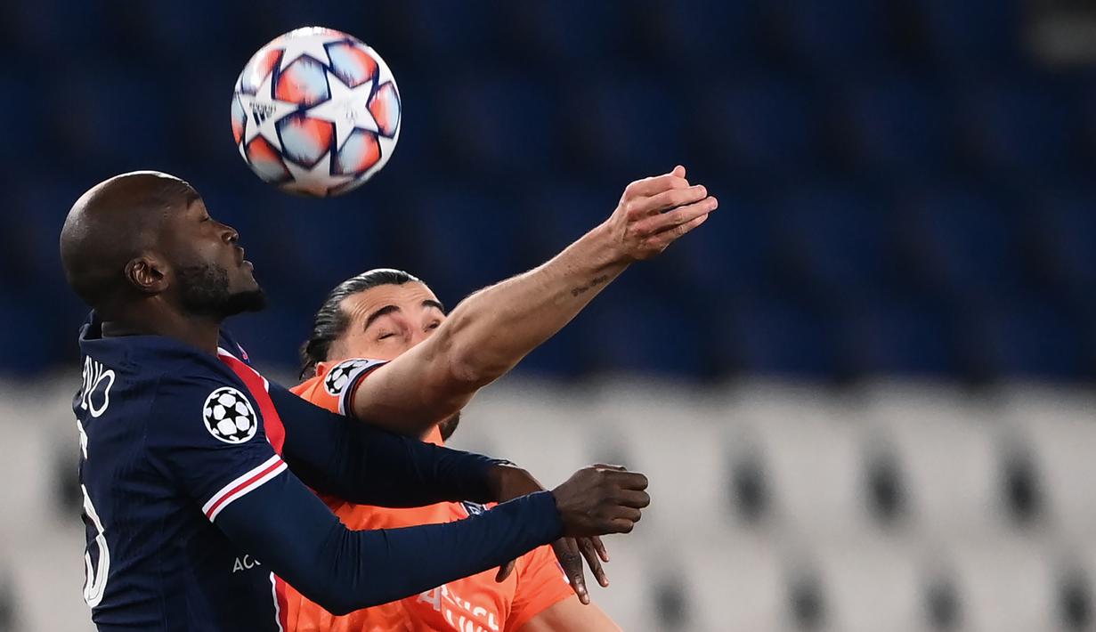 Gelandang Paris Saint-Germain, Danilo Pereira (kiri), berduel udara dengan gelandang Istanbul Basaksehir, Berkay Ozcan, dalam laga lanjutan Liga Champions Grup H antara PSG melawan Istanbul Basaksehir di Parc des Princes Stadium, Selasa (8/12/2020). (AFP/Franck Fife)