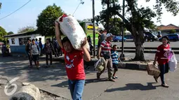 Seorang pria tampak memanggul karung di Terminal Pulo Gadung, Jakarta, Selasa (22/7/2015). Arus balik di Terminal Pulogadung hingga H+4 Lebaran mengalami peningkatan dibanding tahun lalu. (Liputan6.com/Faizal Fanani)