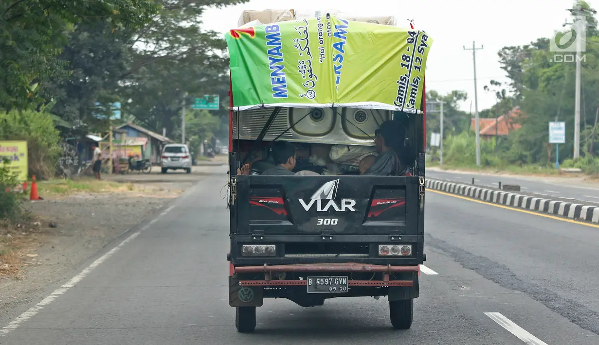 Pemudik bersama keluarganya menggunakan motor bak roda tiga saat perjalanan mudik melintasi Jalur Pantura kawasan Pemalang, Jawa Tengah, Senin (3/6/2019). Keluarga ini menuju kampung halamannya di Banjarnegara, Jawa Tengah. (Liputan6.com/Herman Zakharia)