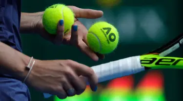 Tangan dengan cat kuku biru milik petenis Denmark, Caroline Wozniacki saat bertanding menghadapi petenis Slovakia Magdalena Rybarikova pada gelaran turnamen tenis Australia Terbuka 2018 di Melbourne, Minggu (21/1).  (AP Photo / Dita Alangkara)