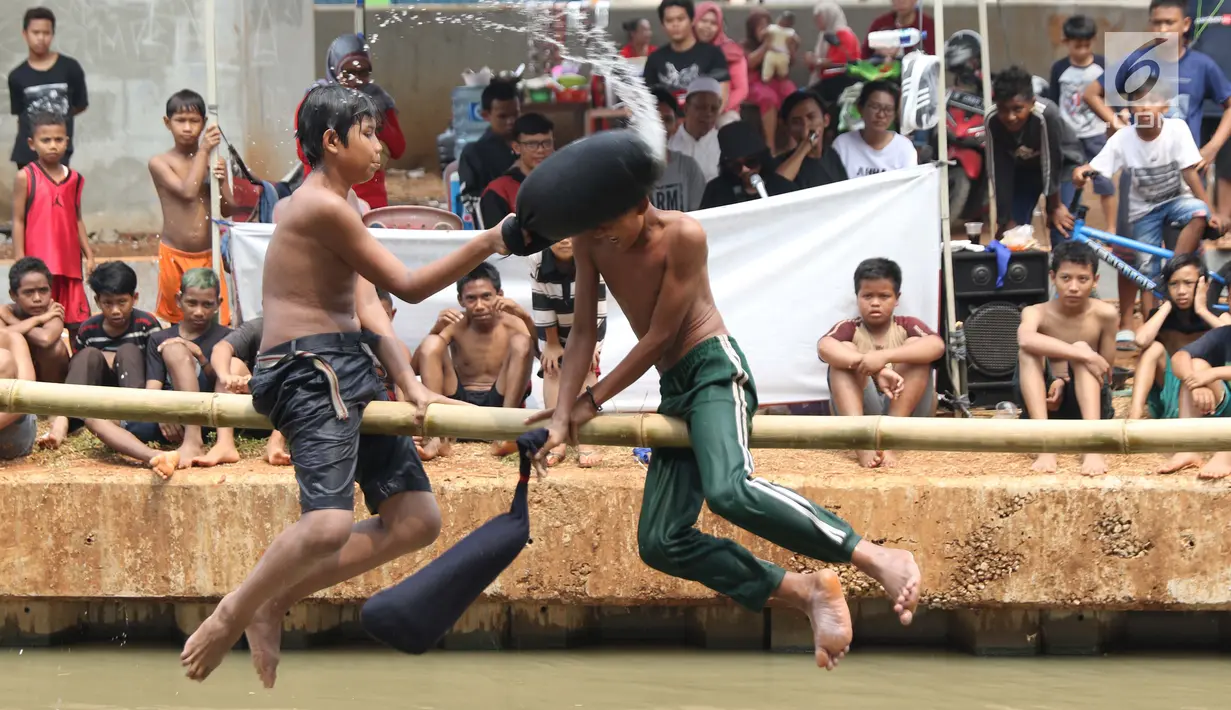 Anak-anak bermain lomba pukul bantal di sekitar Kalimalang, Jakarta, Sabtu (17/8/2019). Beragam lomba permainan digelar warga untuk menyemarakkan HUT ke-74 Republik Indonesia. (Liputan6.com/Helmi Fithriansyah)