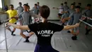 Instruktur balet wanita saat melatih para tentara Korsel belajar tari balet di sebuah pangkalan militer di dekat zona demiliterisasi yang memisahkan kedua negara Korsel dan Korut di Paju, Korea Selatan, (13/7). (REUTERS/Kim Hong-Ji)