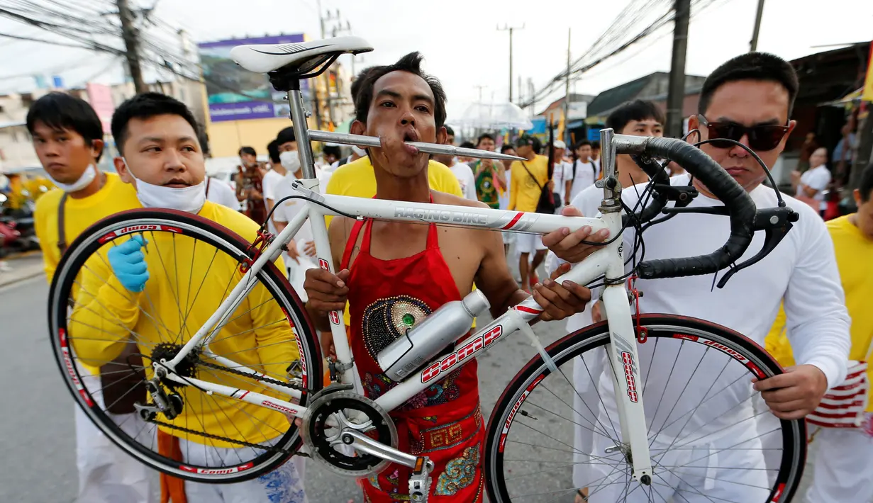 Seorang pemuja dari Kuil Samkong membawa sepeda dengan besi saat Festival Vegetarian di Phuket, Thailand, Selasa (4/10). (REUTERS/Jorge Silva)