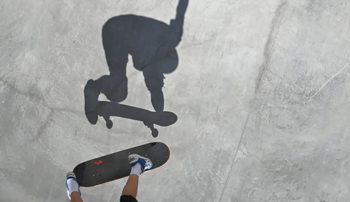 Aksi atlet Skateboard pria terlihat dalam siluet selama berkompetisi dalam Olimpiade Tokyo 2020 di Ariake Sports Park Skateboarding di Tokyo, Jepang, Kamis (5/8/2021). (AFP/Loic Venance)