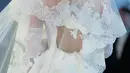 Nicola Peltz tampil cantik dengan gaun panjang berwarna putih dengan aksen tali di bagian belakang. Menurut stylist Nicola, penampilannya semakin spektakuler dengan ornamen renda Prancis sebagai veil. (Vogue.com/Corbin Gurkin)