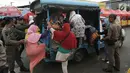 Petugas Satpol PP membantu warga menaiki mobil patroli mereka di jalan Jatibaru Raya, Jakarta, Selasa (30/1). Petugas menawarkan tumpangan kepada warga lantaran tak beroperasinya Bus TransJakarta Tanah Abang Explorer. (Liputan6.com/Gempur M Surya)