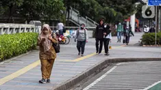 Sejumlah pekerja berjalan usai bekerja di Jalan Jenderal Sudirman, Jakarta, Selasa (10/5/2022). Pemerintah mengimbau masyarakat menerapkan bekerja dari rumah atau work from home (WFH) selama satu hingga dua pekan ke depan untuk mengantisipasi penyebaran virus corona COVID-19 usai libur Lebaran 2022. (Liputan6.com/Faizal Fanani)