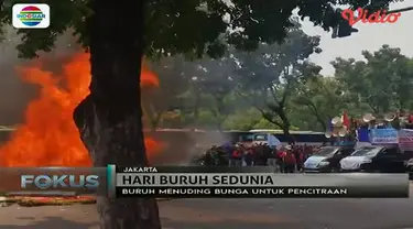 Karangan bunga yang berhari-hari tidak dibersihkan di depan Balai Kota DKI Jakarta dibakar buruh.