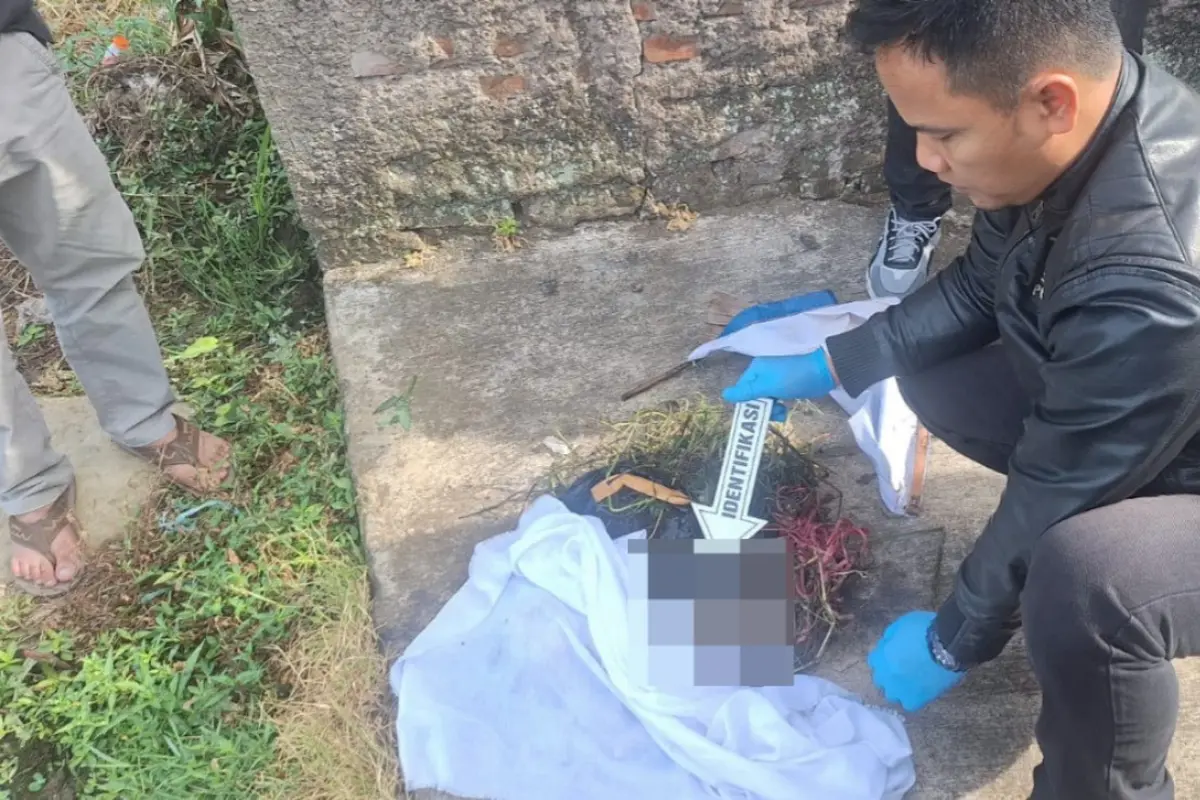 Anggota Polsek Garut Kota beserta Unit Inafis Polres Garut tengah melakukan olah kejadian perkara penemuan bayi mungil laki-laki di jalan Gang Pesawahan, Garut Kota, Kabupaten Garut. (Liputan6.com/Jayadi Supriadin)