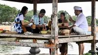 Dalam kunjungannya, Gibran Rakabuming Raka dibacakan kakawin dan meminum jamu kelor oleh Co Founder Samsara Living Museum, Ida Bagus Agung Gunarthawa. (SONNY TUMBELAKA/AFP)