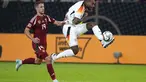 Bek Jerman Jonathan Tah menendang bola saat penyerang Hungaria Barnabas Varga mencoba menghentikannya pada ertandingan pertama grup C UEFA Nations League 2024,, Minggu (8/9/2024) dini hari WIB. (AP Photo/Michael Probst)