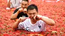 Kontestan memakan cabai saat mengambil bagian dalam kompetisi makan cabai di Ningxiang di provinsi Hunan tengah, China (8/7). Pemenang dalam kontes ini telah memakan 5 cabai dalam waktu satu menit. (AFP Photo)