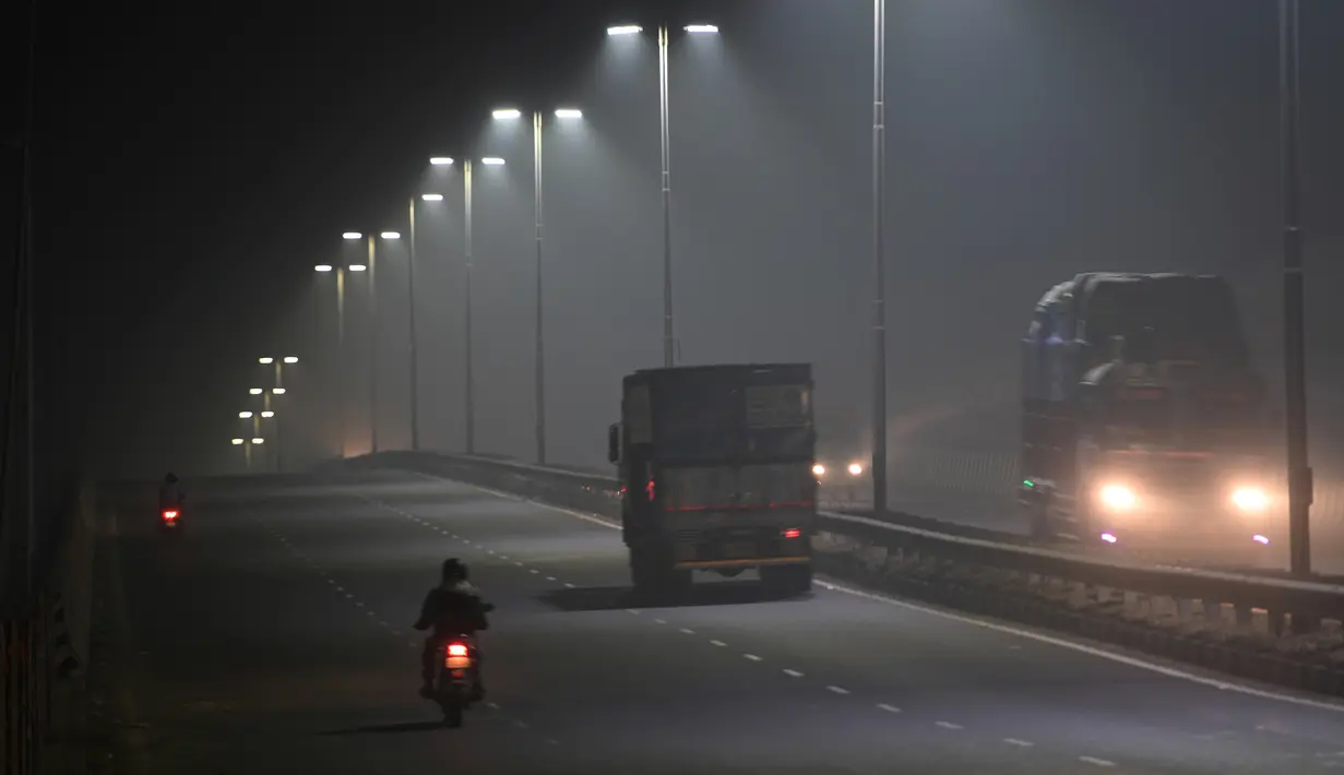 Kendaraan melintas di tengah kabut asap di Faridabad, pinggiran New Delhi, India (2/11). Tingkat kabut melonjak selama musim dingin di Delhi, ketika kualitas udara melampaui tingkat aman Organisasi Kesehatan Dunia. (AP Photo/Money Sharma)