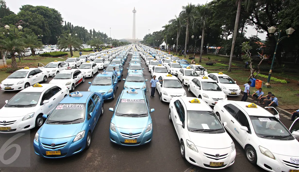 Ratusan armada taksi parkir di sepanjang silang Monas, Jakarta, (14/3). Mereka merasa dirugikan dengan banyaknya tranportasi berplat hitam yang berbasis online tersebut. (Liputan6.com/Immanuel Antonius)