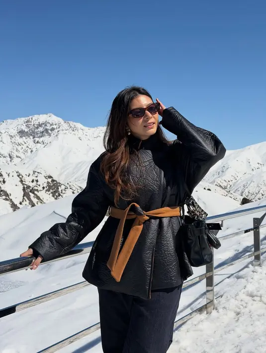 Berlatar pegunungan bersalju, Shalom Razade tampil kontras dengan outfit musim dingin serba hitam [@sharazaaa]