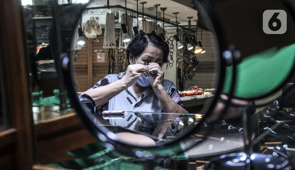 Calon pembeli menggunakan kaca pembesar untuk melihat detail batu berlian di toko perhiasan di Pasar Rawa Bening, Jatinegara, Jakarta, Kamis (11/11/2021). Pemilik toko mengatakan pandemi COVID-19 membuat daya beli masyarakat terhadap berlian turun hingga 50 persen. (merdeka.com/Iqbal S. Nugroho)