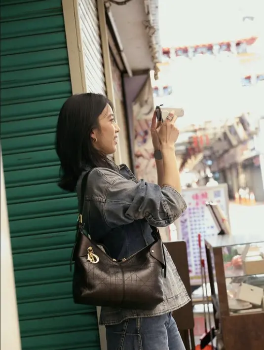 <p>Annie Chen tampil casual dalam balutan denim on denim serta tas Dior Voyage Bag. [Foto: Dior.dok]</p>