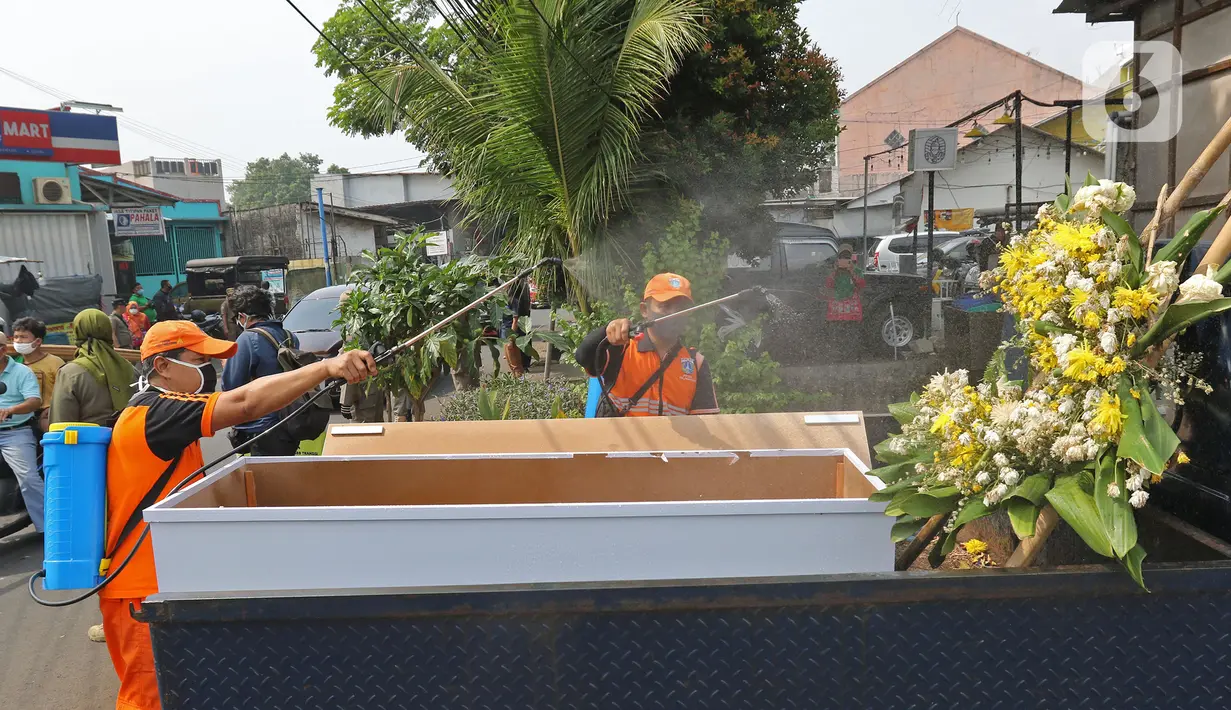 Petugas menyemprotkan cairan disinfektan ke peti mati di Kawasan Kalisari, Pasar Rebo, Jakarta Timur, Kamis (3/9/2020). Warga Kelurahan Pasar Rebo yang tidak menggunakan masker diberikan pilihan hukuman, salah satunya dimasukkan ke dalam peti mati selama 1 menit. (Liputan6.com.Herman Zakharia)