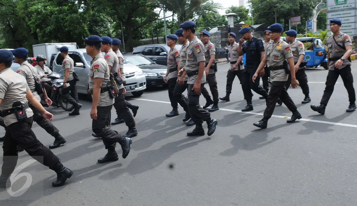 Sejumlah petugas kepolisian saat tiba di Gereja Katedral, Jakarta, Sabtu (24/12). Penjagaan oleh polisi dilakukan untuk menjaga kondusifitas agar acara Malam Misa Natal bisa berjalan lancar. (Liputan6.com/Helmi Afandi) 