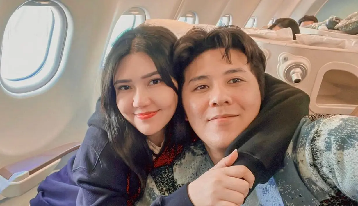 Selfie di dalam pesawat, Via Vallen tampil kompak dengan suami. Via Vallen tampak mengenakan jaket biru, mengalungkan lengannya di pundak suami yang mengenakan atasan bermotif abstrak. Foto: Instagram.