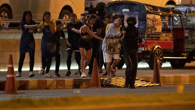 Tentara mengawal pengunjung yang keluar dari mal Terminal 21 Korat saat terjadi penembakan di Nakhon Ratchasima, Thailand, Minggu (9/2/2020). Akibat penembakan tersebut sebanyak 20 orang tewas. (AP Photo/Sakchai Lalitkanjanakul)
